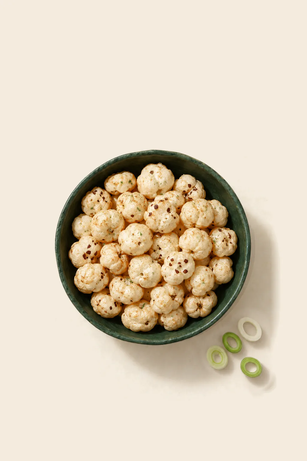 Roasted makhana in a cream and onion seasoning, in a green bowl