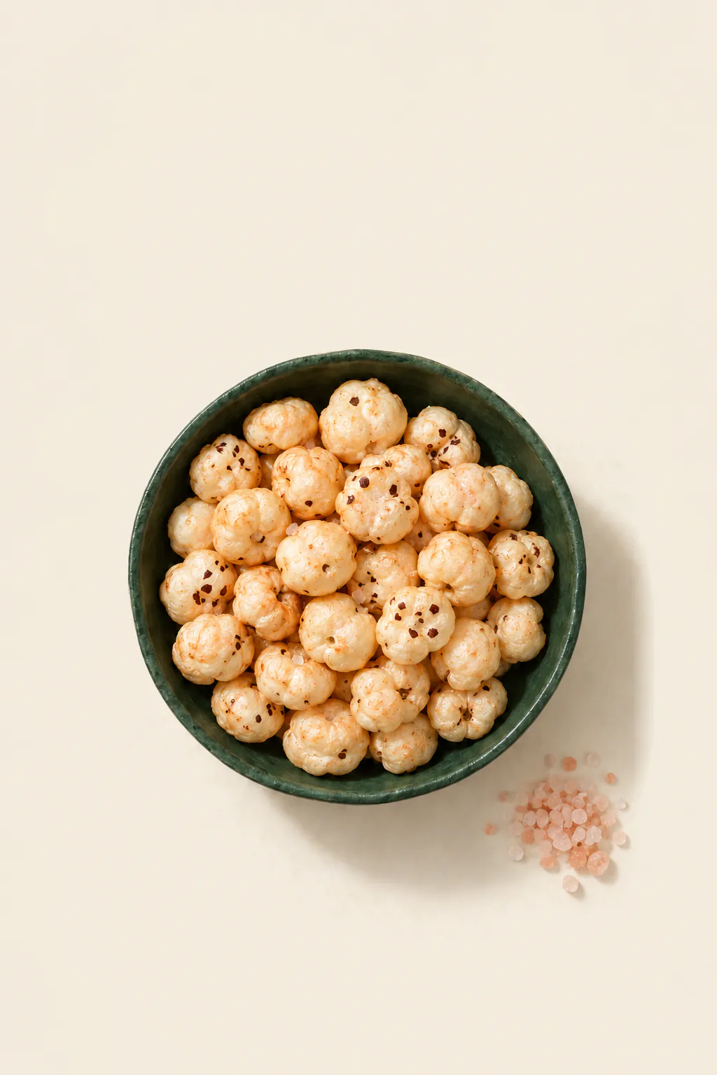 Roasted makhana with pink salt, in a green bowl