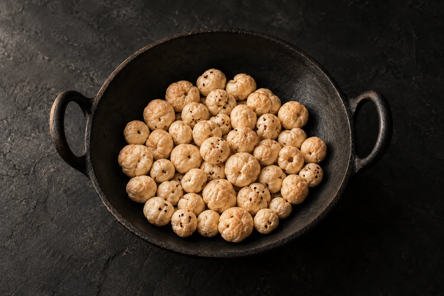 Golden roasted makhana in an iron kadai